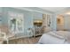 Bright bedroom featuring beachy decor, built-in shelves, plantation shutters, and light wood flooring at 750 N Tamiami Trl # 304, Sarasota, FL 34236
