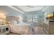 Serene bedroom with soft blue walls, white bedding, plantation shutters, and ample natural light at 750 N Tamiami Trl # 304, Sarasota, FL 34236