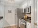 Compact kitchen featuring stainless steel appliances, white cabinets, and modern countertops at 750 N Tamiami Trl # 304, Sarasota, FL 34236
