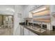 Kitchen with stainless steel sink, granite countertops, and a view of the dining area at 750 N Tamiami Trl # 304, Sarasota, FL 34236