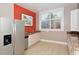 Bright kitchenette with stainless steel refrigerator, granite countertops, white cabinets, and a large window at 750 N Tamiami Trl # 304, Sarasota, FL 34236