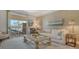 Bright living room with neutral decor, a comfortable sofa, and a sliding door to a private balcony at 750 N Tamiami Trl # 304, Sarasota, FL 34236