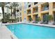 Pool with chaise lounges and umbrellas, surrounded by palm trees and lush landscaping at 750 N Tamiami Trl # 304, Sarasota, FL 34236