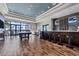 Clubhouse bar with seating, dark wood floors, and floor to ceiling windows showcasing the community at 7643 Haddington Cv, Bradenton, FL 34202