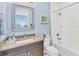 Cozy bathroom features a granite vanity, framed mirror, and a shower-tub combination at 7643 Haddington Cv, Bradenton, FL 34202