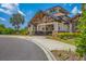 Elegant clubhouse entrance featuring stone accents, grand columns, and lush landscaping under a bright blue sky at 7643 Haddington Cv, Bradenton, FL 34202
