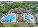 Aerial view of the community pools with sunshades and lots of chairs, surrounded by trees at 7643 Haddington Cv, Bradenton, FL 34202