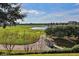 Scenic view of golf course showcasing lush green fairways, mature trees, and a serene pond with a golf cart at 7643 Haddington Cv, Bradenton, FL 34202
