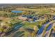Aerial view of the clubhouse surrounded by lush landscaping, golf course, and parking lot at 7643 Haddington Cv, Bradenton, FL 34202