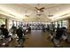 A well-equipped gym features a variety of exercise machines and plenty of natural light from expansive windows at 7643 Haddington Cv, Bradenton, FL 34202