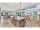 Open-concept kitchen with a spacious island, modern appliances, pendant lights, and a view of the living and dining areas at 7643 Haddington Cv, Bradenton, FL 34202