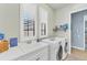 Functional laundry room with modern appliances, a sink, and plentiful natural light at 7643 Haddington Cv, Bradenton, FL 34202