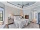 Bright main bedroom with tray ceilings, luxury bedding, hardwood floors, and elegant furnishings at 7643 Haddington Cv, Bradenton, FL 34202