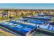 Aerial view of several pickleball courts in a beautiful community with lush landscaping, and nearby pond at 7643 Haddington Cv, Bradenton, FL 34202