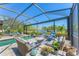 Relaxing screened pool area with comfortable seating overlooking the serene lake at 7643 Haddington Cv, Bradenton, FL 34202