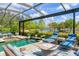 Screened pool area featuring comfortable seating, a waterfall, and beautiful lake views at 7643 Haddington Cv, Bradenton, FL 34202