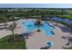 Aerial view of the resort-style pool and surrounding amenities including palm trees and lounge chairs at 7643 Haddington Cv, Bradenton, FL 34202