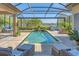 Stunning screened-in pool area with lake view and outdoor lounge seating at 7643 Haddington Cv, Bradenton, FL 34202