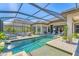 Serene backyard pool area with waterfall feature, lush landscaping and a screened enclosure at 7643 Haddington Cv, Bradenton, FL 34202
