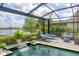 Screened pool area features a waterfall and lounge seating with beautiful lake views at 7643 Haddington Cv, Bradenton, FL 34202