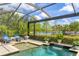 Beautiful pool and spa with water feature, lush landscaping and a screened enclosure at 7643 Haddington Cv, Bradenton, FL 34202