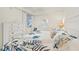 Light-filled bedroom with tropical bedding, side tables, and wood flooring at 850 Tidewater Shores Loop # 202, Bradenton, FL 34208