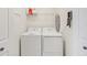 Functional laundry room equipped with a washer, dryer, shelving, and cleaning supplies at 850 Tidewater Shores Loop # 202, Bradenton, FL 34208