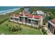 Beautiful aerial view of beachfront condo building with lush lawn, tropical landscaping, and close proximity to the beach at 8710 Midnight Pass Rd # 202, Sarasota, FL 34242