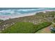 Overhead view of a sandy beach with dune vegetation and tranquil blue ocean waters at 8710 Midnight Pass Rd # 202, Sarasota, FL 34242