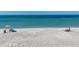 Scenic beach view with calm waters, sandy shores, and people enjoying the sunny weather at 8710 Midnight Pass Rd # 202, Sarasota, FL 34242