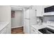 Clean, modern kitchen with white appliances and countertops and view of an adjacent room at 8710 Midnight Pass Rd # 202, Sarasota, FL 34242