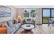 Comfortable living room with neutral decor, hardwood floors, large windows, and a partial ocean view at 8710 Midnight Pass Rd # 202, Sarasota, FL 34242