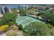 Aerial view of lushly landscaped tennis courts with surrounding residences and tropical trees at 8710 Midnight Pass Rd # 202, Sarasota, FL 34242