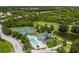 Aerial view of the community, showing the pool, tennis courts, and surrounding green landscape at 6314 Bay Cedar Ln # 201, Bradenton, FL 34203