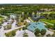 Beautiful aerial view of the community clubhouse, pool, tennis courts, and a serene lake and golf course at 6314 Bay Cedar Ln # 201, Bradenton, FL 34203