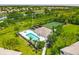 Aerial view of the community pool, spa, tennis courts, and meticulously landscaped grounds at 6314 Bay Cedar Ln # 201, Bradenton, FL 34203