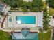 Overhead view of the pool area with a spa, lounge chairs, and lush landscaping at 6314 Bay Cedar Ln # 201, Bradenton, FL 34203