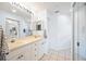 Bright bathroom featuring dual sinks, vanity with white cabinets, and a large mirror with modern lighting fixtures at 6314 Bay Cedar Ln # 201, Bradenton, FL 34203