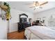 Bright bedroom boasts hardwood floors, a ceiling fan, a double bed, workspace, and a dark dresser at 6314 Bay Cedar Ln # 201, Bradenton, FL 34203