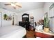 This bedroom features hardwood floors, a ceiling fan, a bed, dresser and workspace at 6314 Bay Cedar Ln # 201, Bradenton, FL 34203