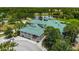 Large community clubhouse with a green roof situated on a lake, surrounded by mature trees and landscaping at 6314 Bay Cedar Ln # 201, Bradenton, FL 34203