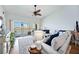 Bright living room with lake views, a ceiling fan and a comfortable couch with blue pillows at 6314 Bay Cedar Ln # 201, Bradenton, FL 34203