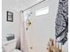 Shower stall with white tile, shower head, small window, and a clear shower curtain for a bright and clean appearance at 6314 Bay Cedar Ln # 201, Bradenton, FL 34203