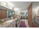 Bathroom with a double sink vanity, granite countertops, and mirrored wall that reflects into the bedroom at 101 Sunset Dr # 102, Sarasota, FL 34236