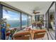 Open-concept living room with floor-to-ceiling windows offering panoramic ocean views and a fan at 101 Sunset Dr # 102, Sarasota, FL 34236
