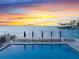 Waterfront pool and lounge chairs offer stunning water views and relaxation at sunset at 101 Sunset Dr # 102, Sarasota, FL 34236