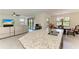 Bright kitchen with granite countertops and stainless steel sink, seamlessly connected to the living area at 10111 Malachite Dr, Bradenton, FL 34211