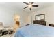 Well-lit main bedroom showcasing wood floors, a dresser, a reading chair, and ensuite bathroom access at 10111 Malachite Dr, Bradenton, FL 34211