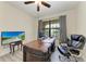 Home office with wood-look floors, desk and ergonomic chair, plus a TV on a side table at 10111 Malachite Dr, Bradenton, FL 34211