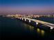 Night aerial view of a cityscape, bridge, and the water with light trails at 1020 Sun N Sea Dr # 104B, Sarasota, FL 34242